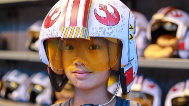 Young shopper wears the helmet of a Star Wars pod racer